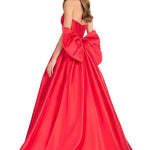 Red evening gown with a large bow detail on a white background