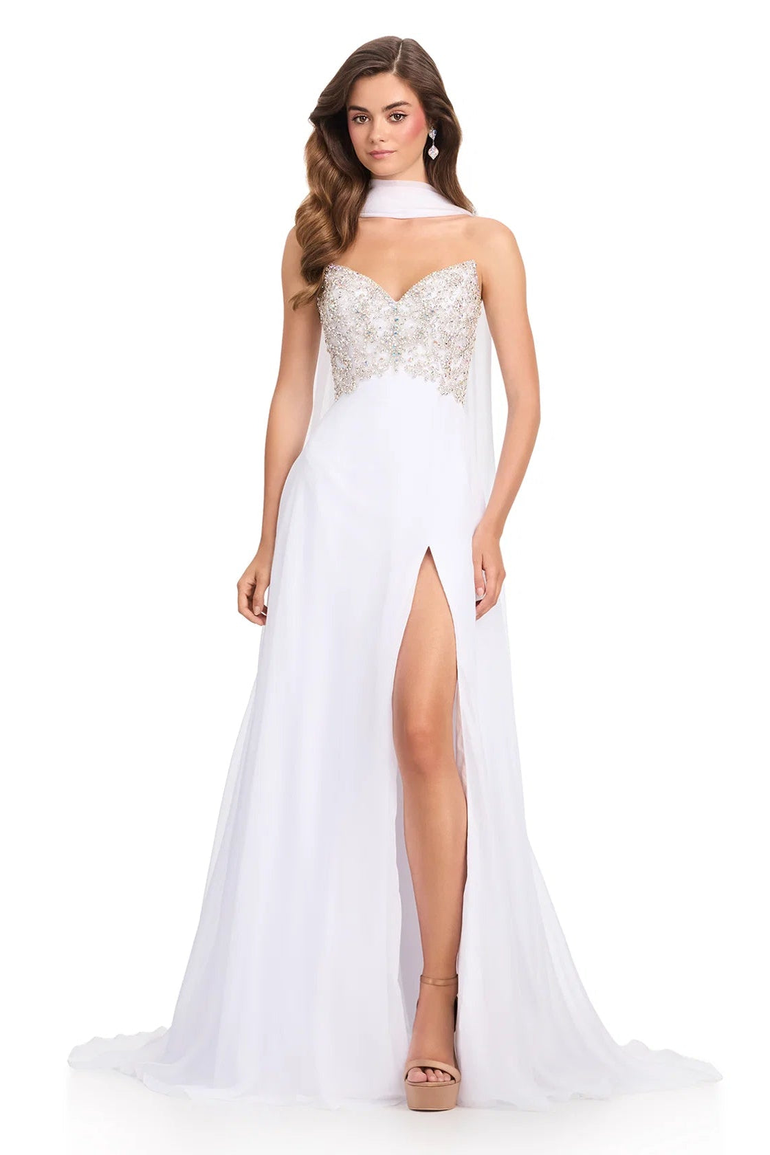 Woman wearing a white evening gown with a high slit on a white background