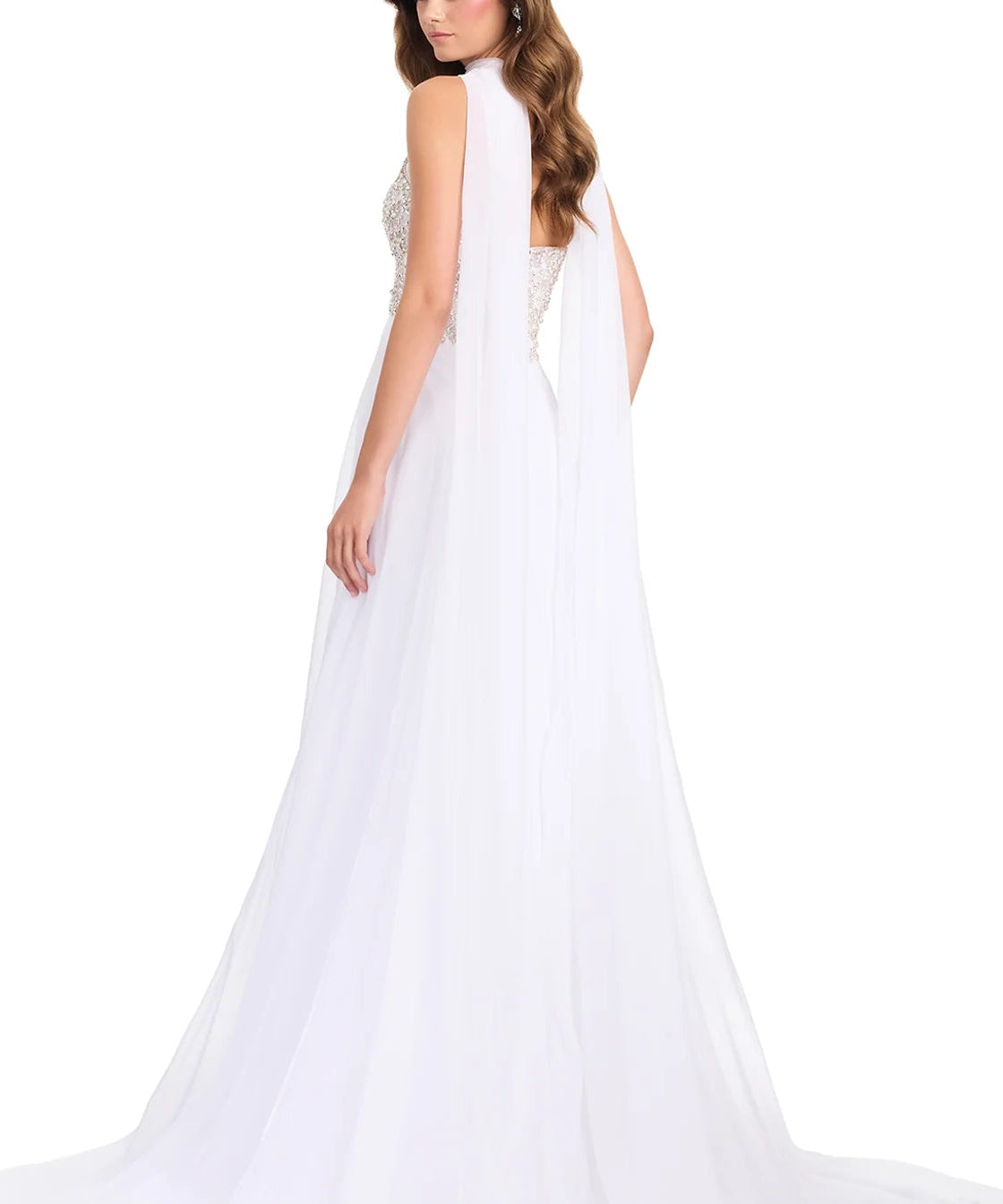 A woman modeling a white bridal gown from the back, featuring a sheer draped cape-style back drape, a beaded open back, and a long flowing tulle train against a plain white studio background.