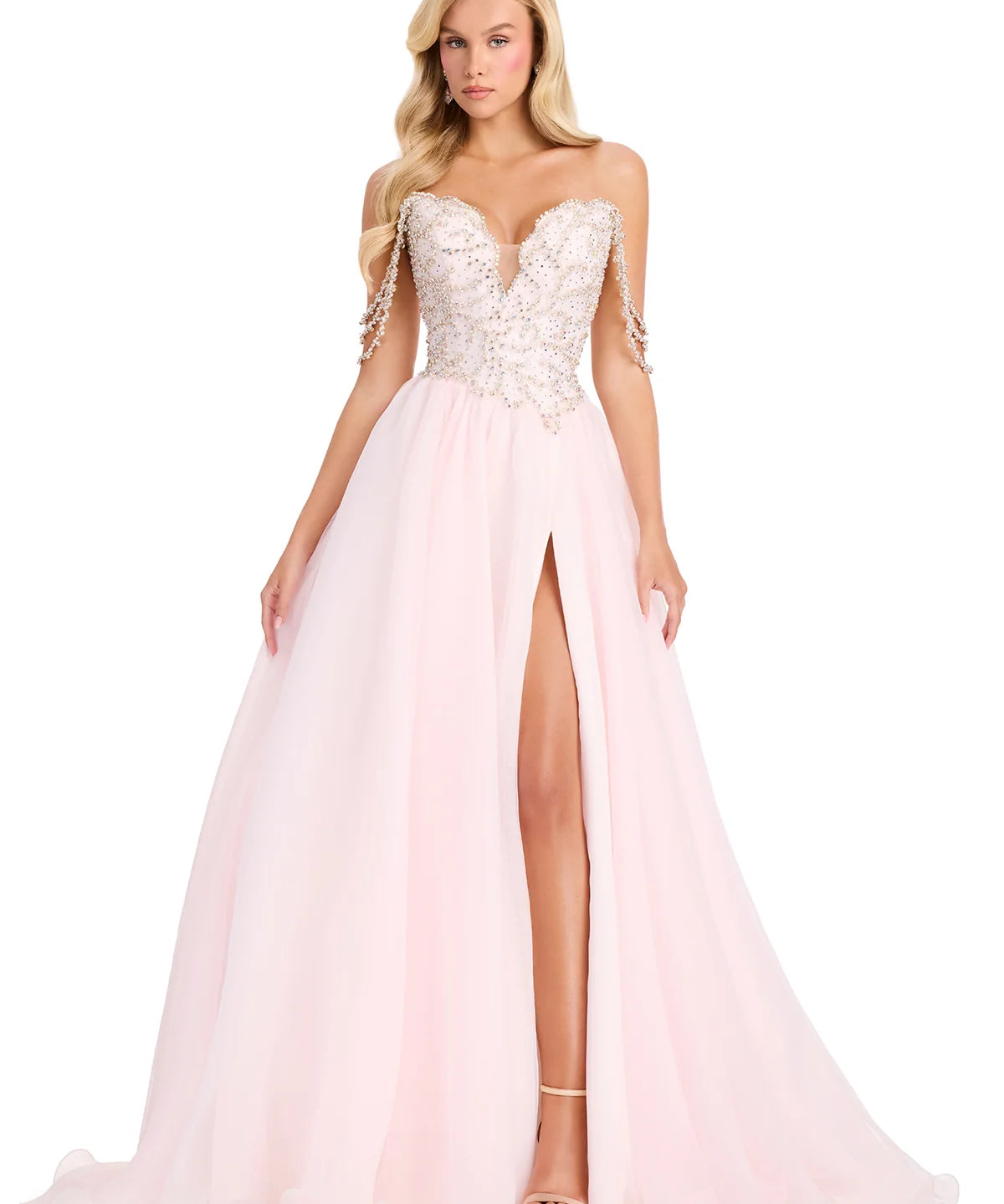 Woman wearing a pink evening gown with a high slit on a white background