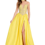 A woman modeling a bright yellow formal gown with a sheer lace bodice, choker neckline, and a thigh slit, photographed against a plain white studio background.