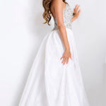 Woman wearing a white wedding dress with a beaded bodice on a white background