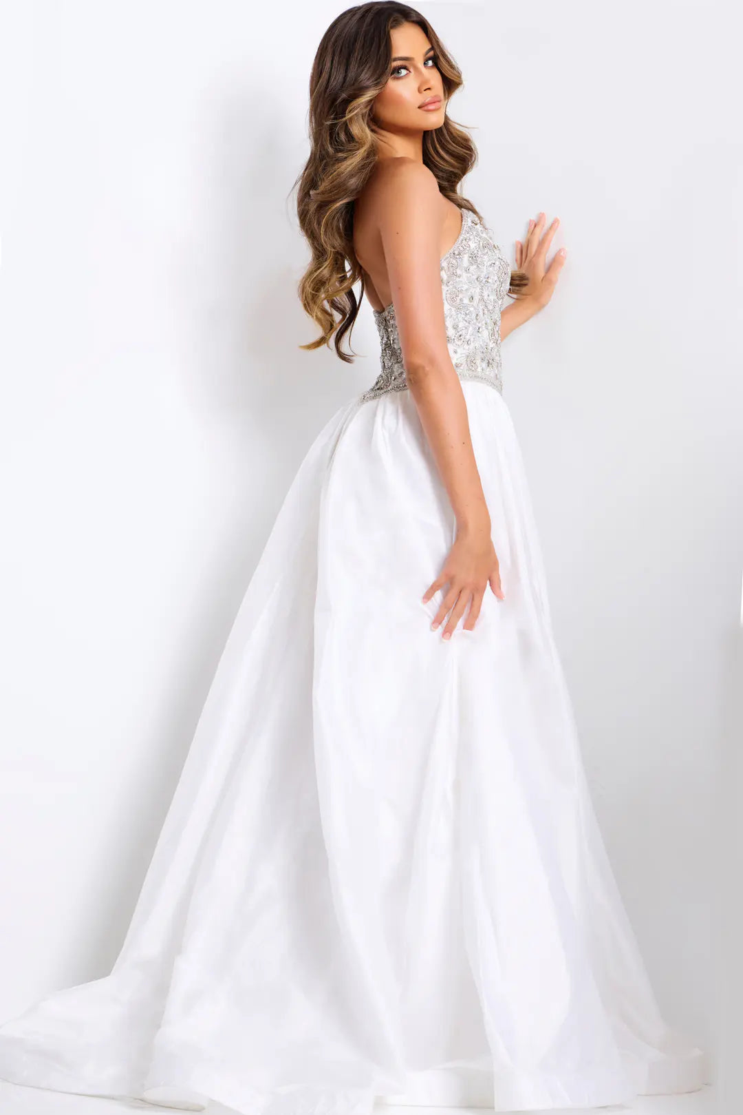 Woman wearing a white wedding dress with a beaded bodice on a white background