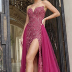 Woman in a pink evening gown with a high slit standing in an elegant interior setting.