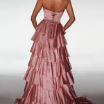 Pink evening gown with tiered layers on a plain background