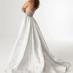 A woman modeling a strapless A-line wedding gown with a textured silver-white lace skirt and a sheer beaded waistband, photographed against a clean white studio background. The brand name 'RACHEL ALLAN' is printed in the top right corner.