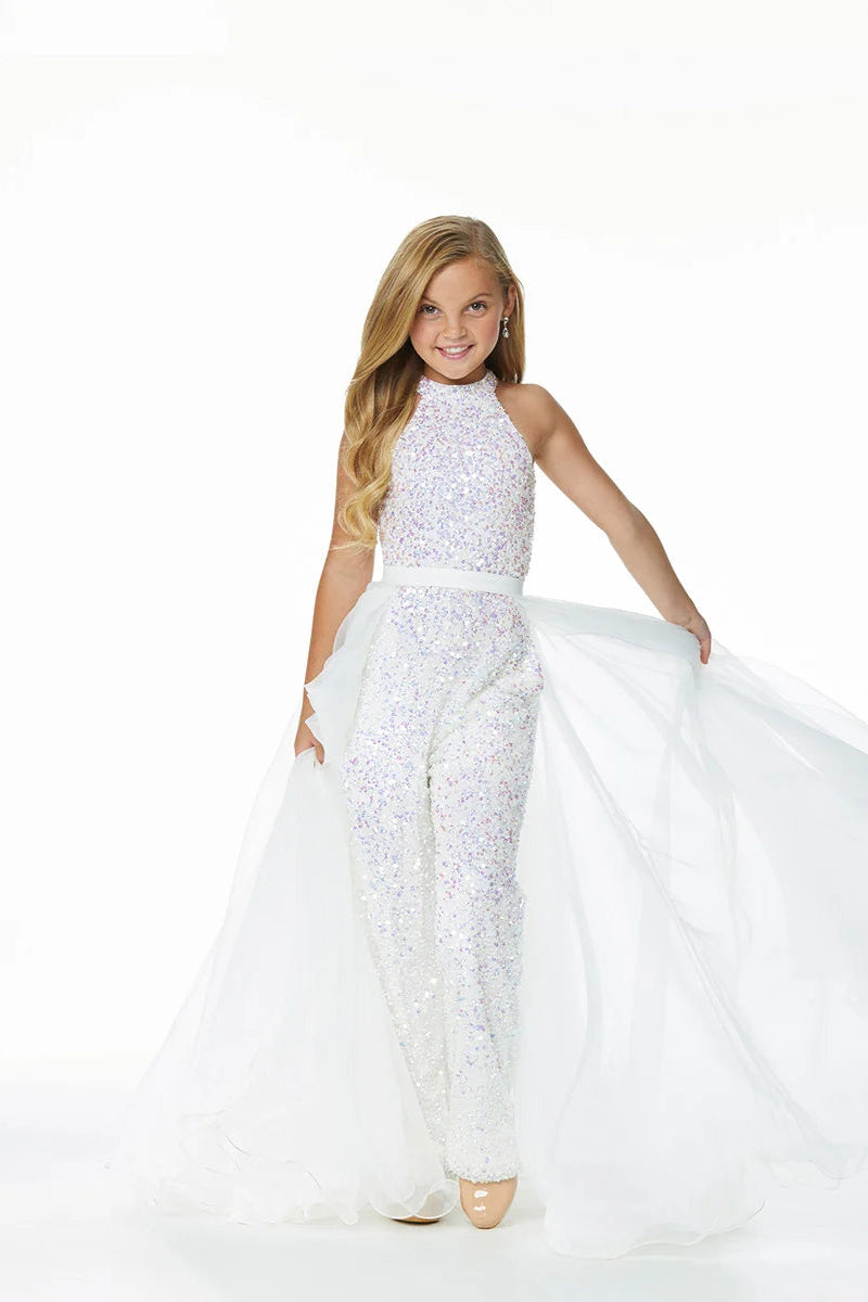Young girl models an ivory organza overskirt atop a stretch glitter jumpsuit.