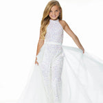 Young girl models an ivory organza overskirt atop a stretch glitter jumpsuit.