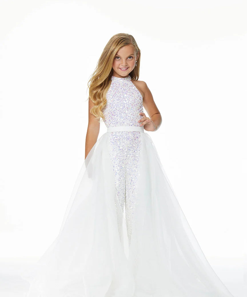 Young girl wearing a white jumpsuit and overskirt on a white background