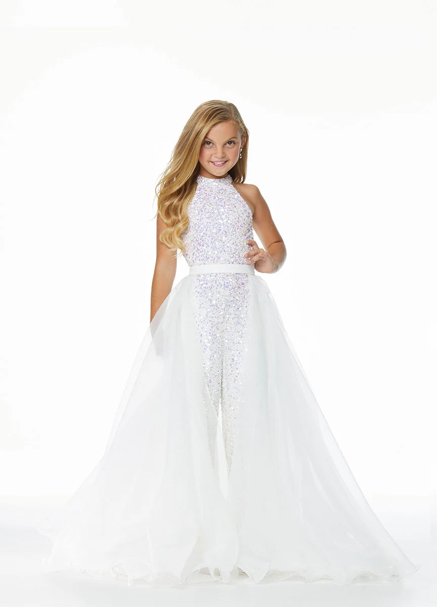Young girl wearing a white jumpsuit and overskirt on a white background