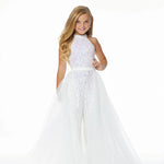 Young girl wearing a white jumpsuit and overskirt on a white background