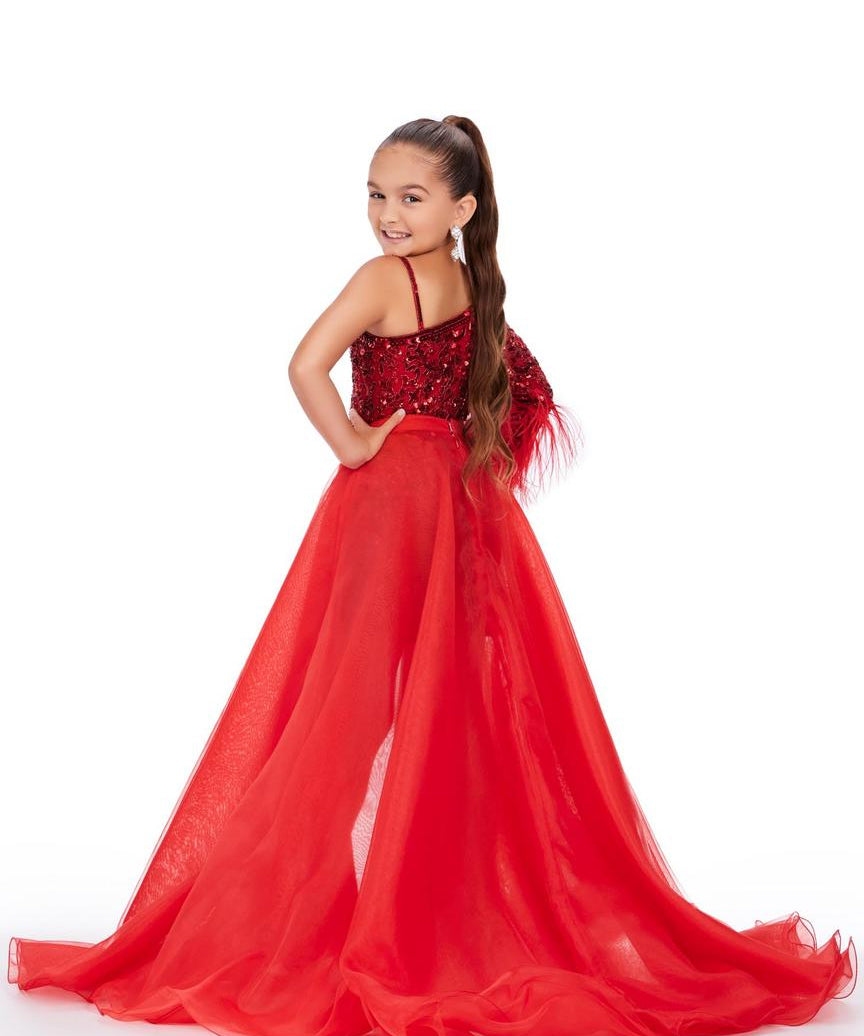 Young girl wearing a red evening gown with a white background