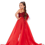 Young girl wearing a red evening gown with a white background