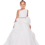 A young girl modeling a white one-shoulder ball gown with a ruffled tulle skirt and a sparkling silver embellished waistband, set against a plain white background.