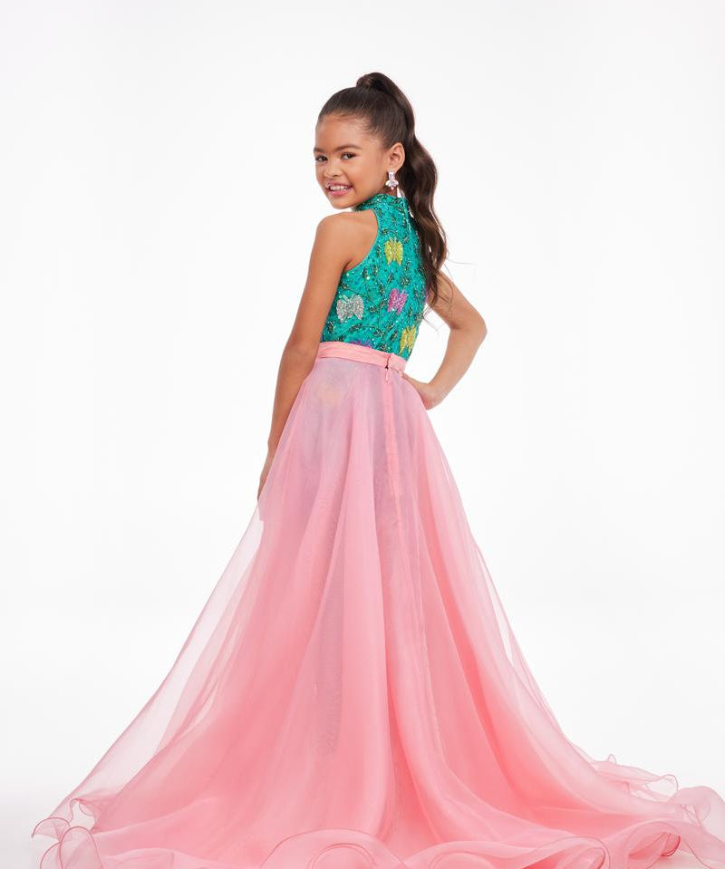 Young girl in a pink and teal formal gown on a white background
