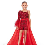 A young girl models a red organza overskirt atop a one shoulder beaded romper in front of a white background.