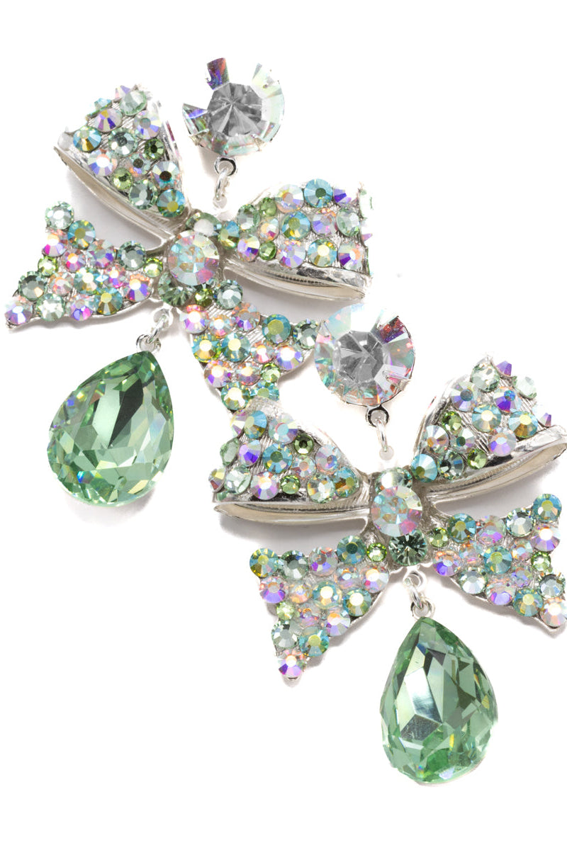 Dazzling earrings with green teardrop crystals and bow design on a white background