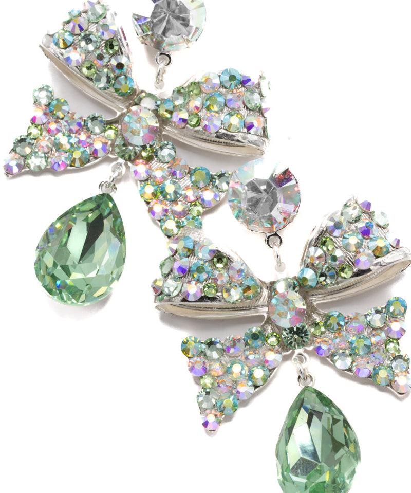 Dazzling earrings with green teardrop crystals and bow design on a white background
