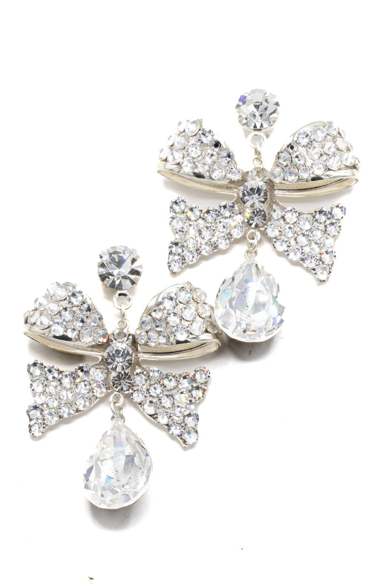 Pair of decorative earrings with bow and teardrop designs on a white background