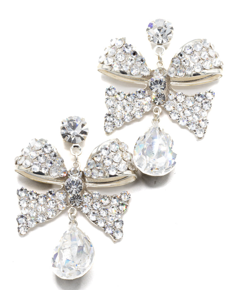 Pair of decorative earrings with bow and teardrop designs on a white background