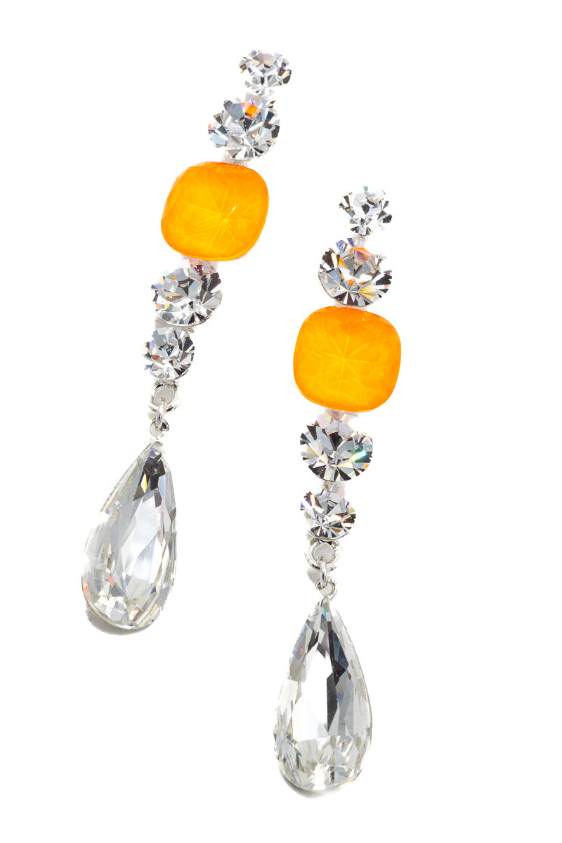 Pair of earrings with orange gemstones and clear teardrop shapes on a white background