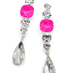 Pair of earrings with pink gemstones and teardrop-shaped crystals on a white background