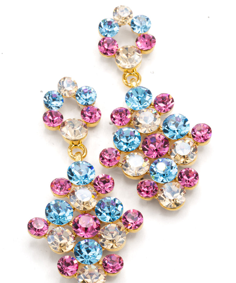 A pair of gold-tone dangle earrings adorned with multiple round-cut rhinestones in light blue, pink, and clear, arranged in a cascading floral cluster design on a white background.