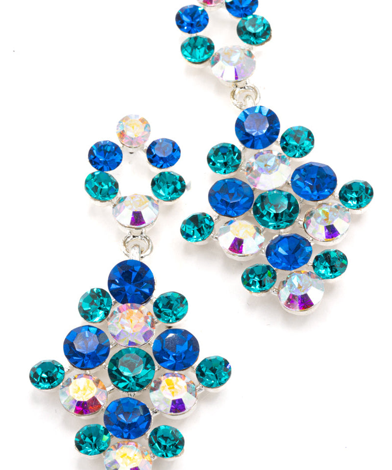 A pair of dangling statement earrings made of faceted rhinestones in royal blue, teal, and iridescent clear, set in silver-tone metal on a white background.