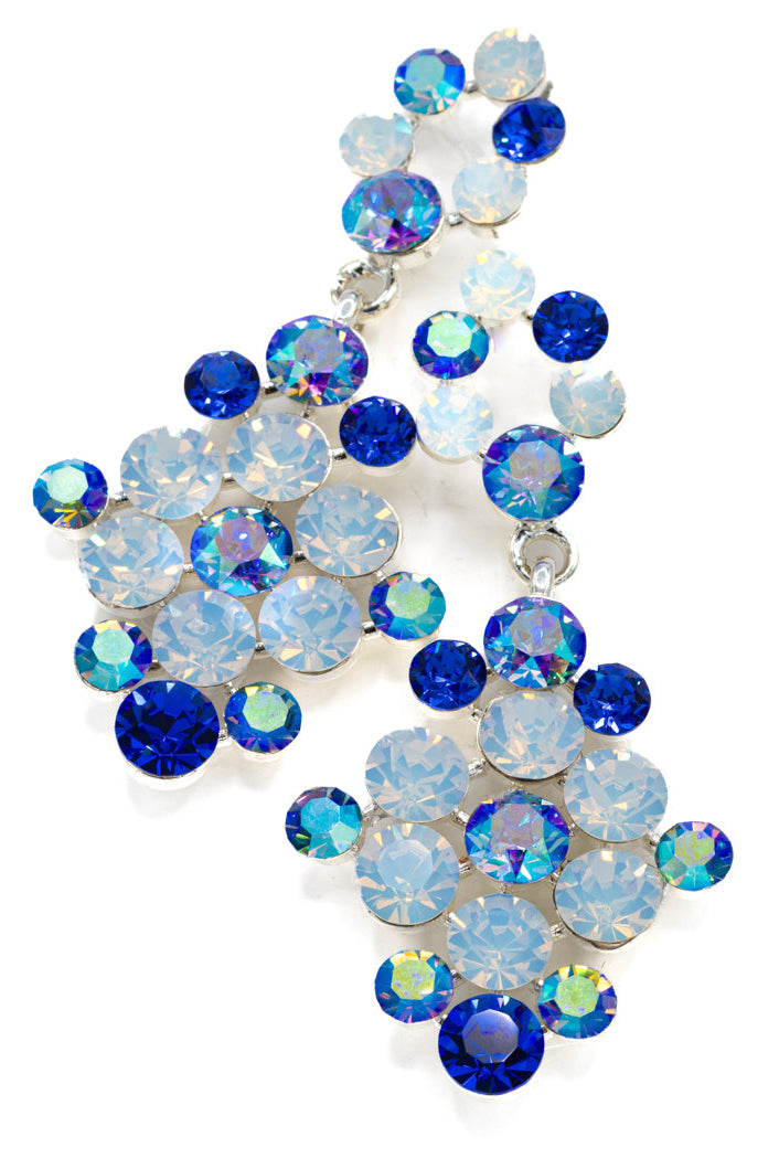 Decorative crystal earrings made of blue and clear opal gemstones on a white background