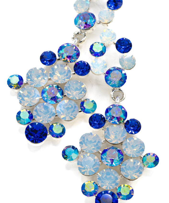 Decorative crystal earrings made of blue and clear opal gemstones on a white background