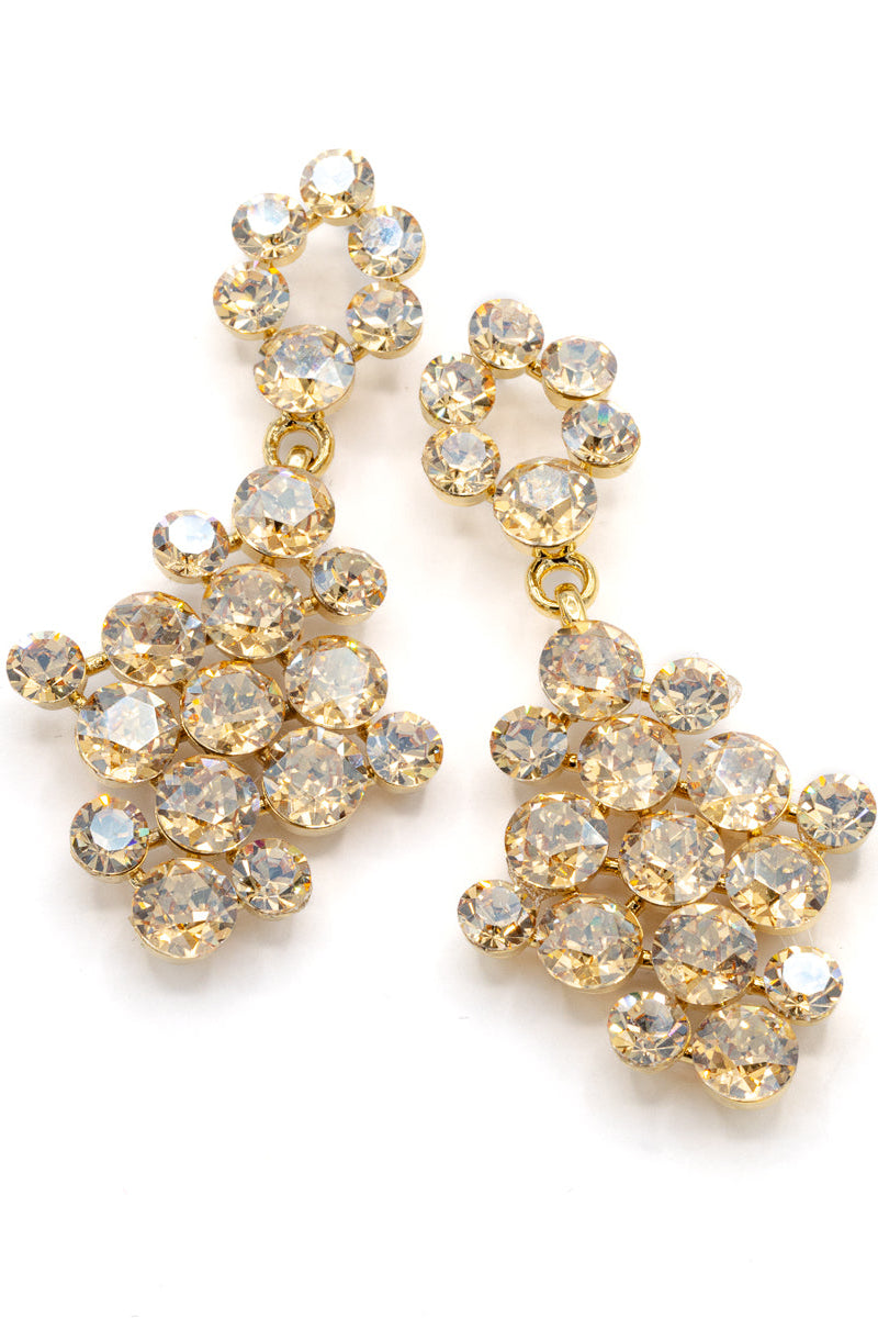 Gold earrings with clear gemstones on a white background