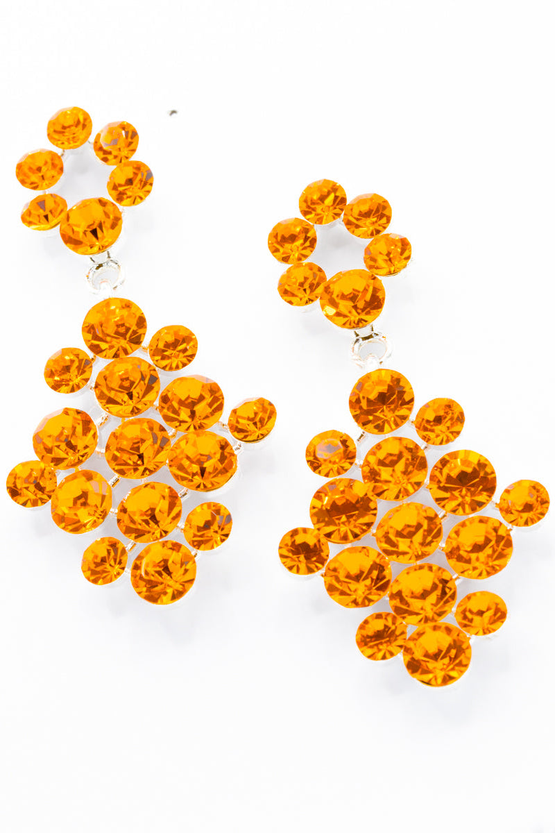 Pair of orange rhinestone earrings on a white background