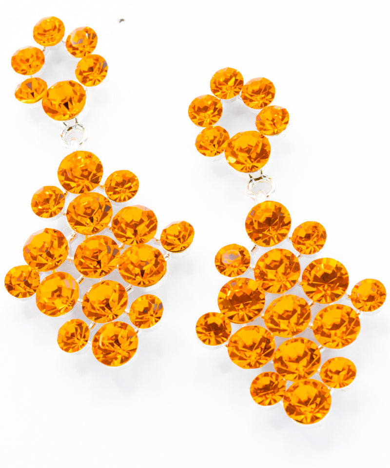 Pair of orange rhinestone earrings on a white background