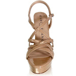 A single Marc DeFang high-heeled platform sandal in a glossy metallic nude-beige patent leather, featuring criss-crossing straps and an ankle strap, shown from a front-facing perspective on a white background.