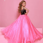 Young girl in a pink and black dress against a pink background with 'Sugar Kaye' branding in stock at RSG Formals