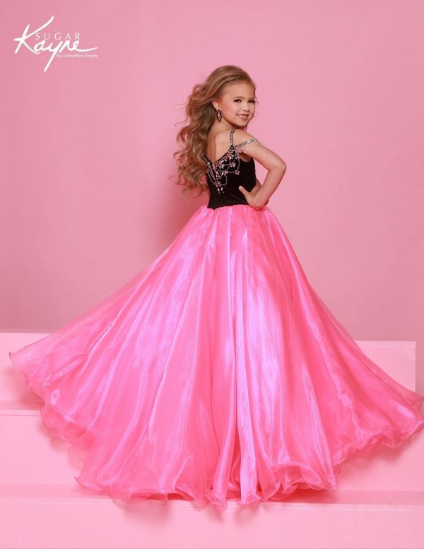 Young girl in a pink and black dress against a pink background with 'Sugar Kaye' branding in stock at RSG Formals