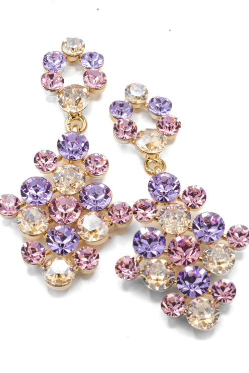 A pair of gold-tone statement dangle earrings adorned with faceted crystal rhinestones in shades of purple, pink, and clear, arranged on a clean white background.
