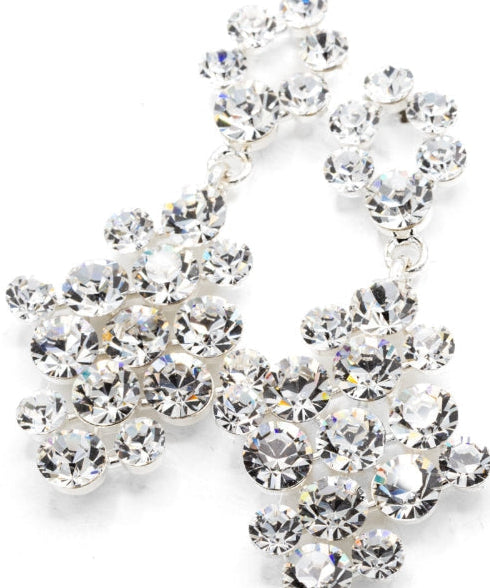 A pair of silver-tone dangle earrings adorned with clear faceted rhinestones, arranged in a cascading floral cluster design on a white background.