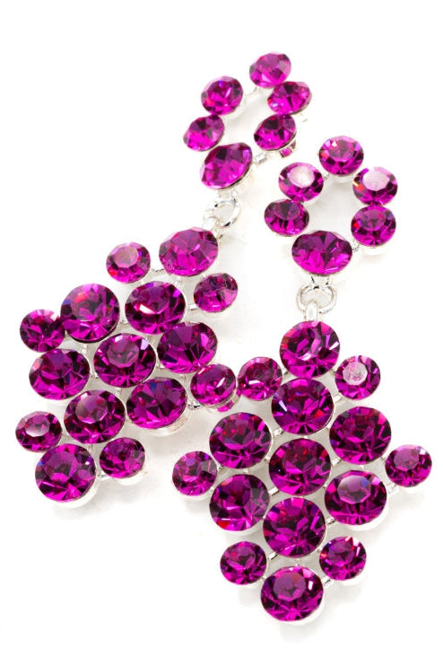 A pair of silver-tone statement earrings adorned with multiple round, faceted fuchsia crystals, set against a plain white background.