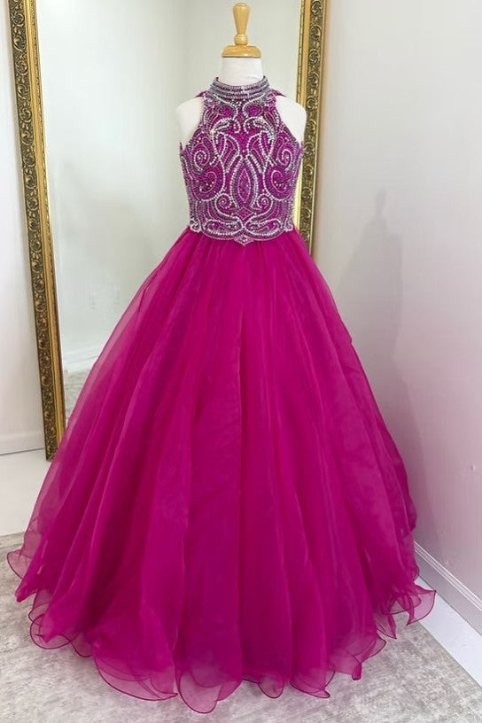 A bright fuchsia pink ball gown with a beaded halter bodice and full tulle skirt, displayed on a mannequin in front of a mirror.